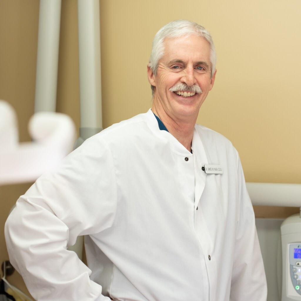 Dr. James M. Nash in white dentist coat in dentists office